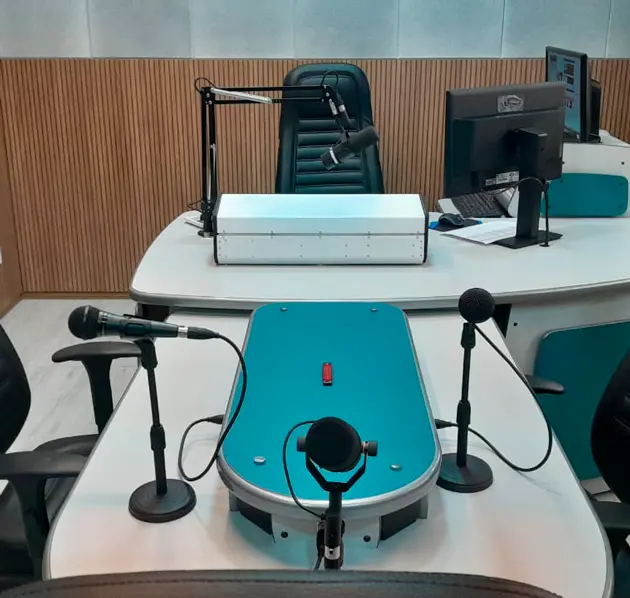 Microfones e bancada de apresentação no estúdio da RITA FM